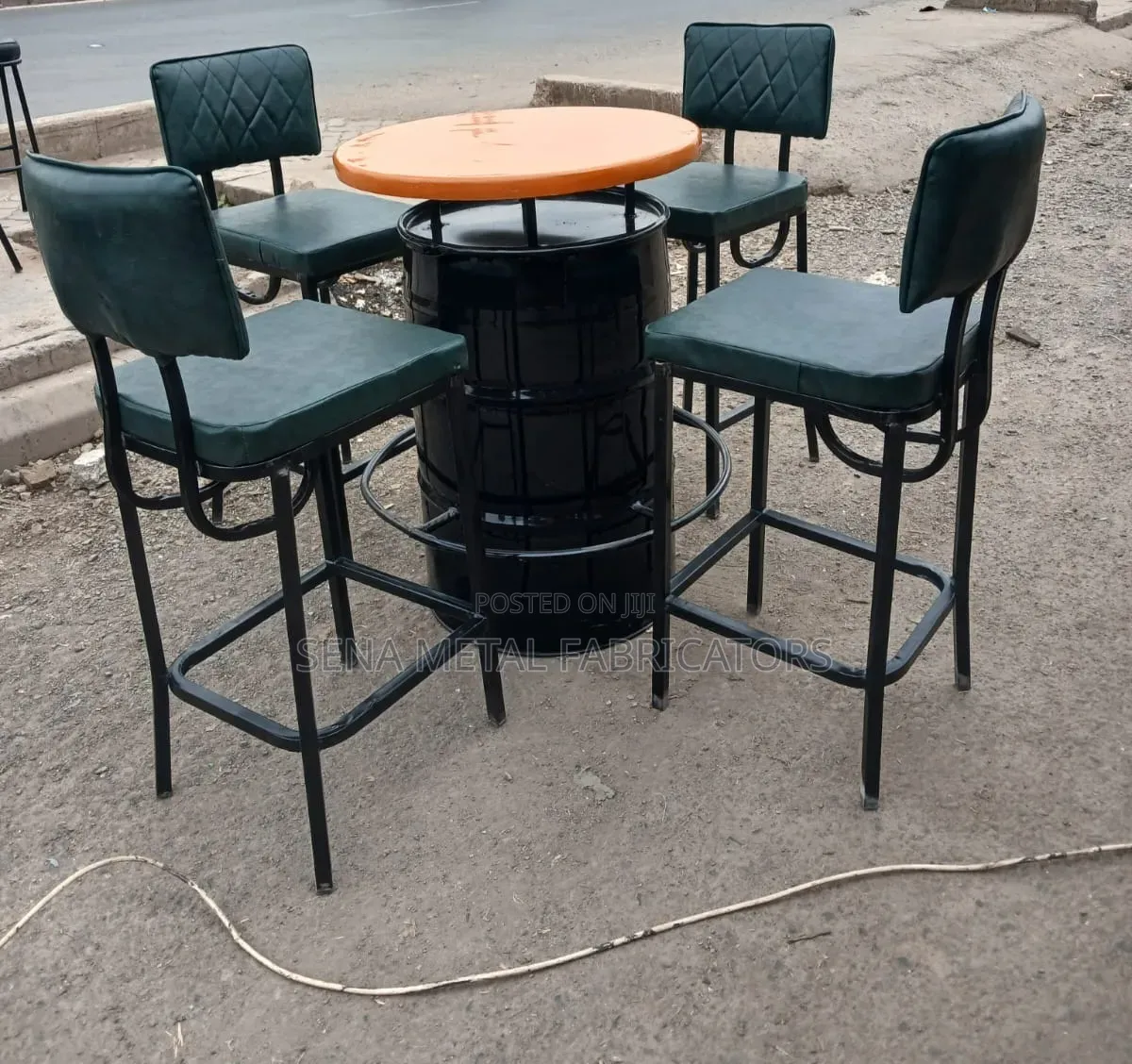 A Metal Drum Set With Green Bar Stools.