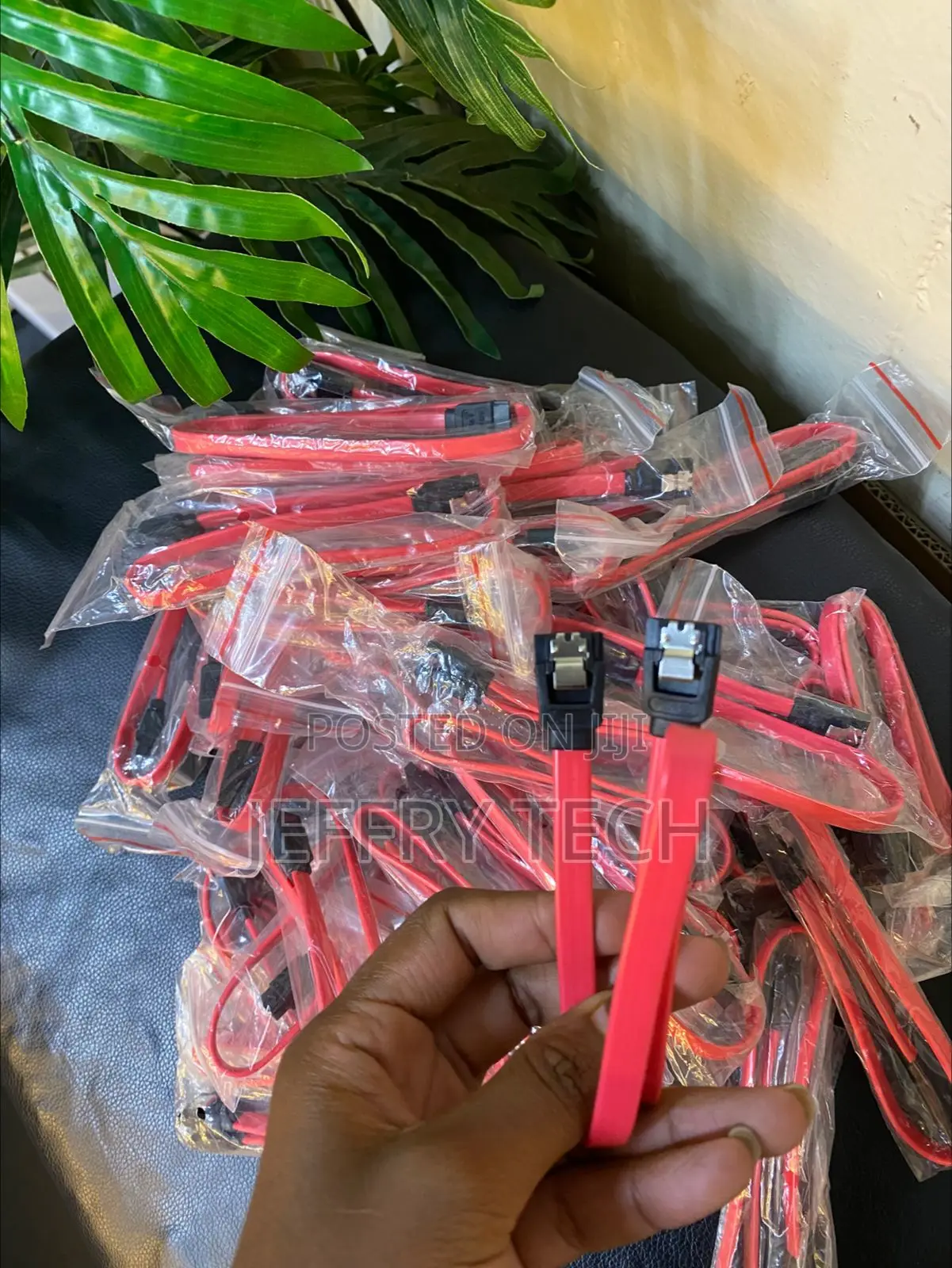 Red SATA Data Cable With Locking Latches Held in a Hand,