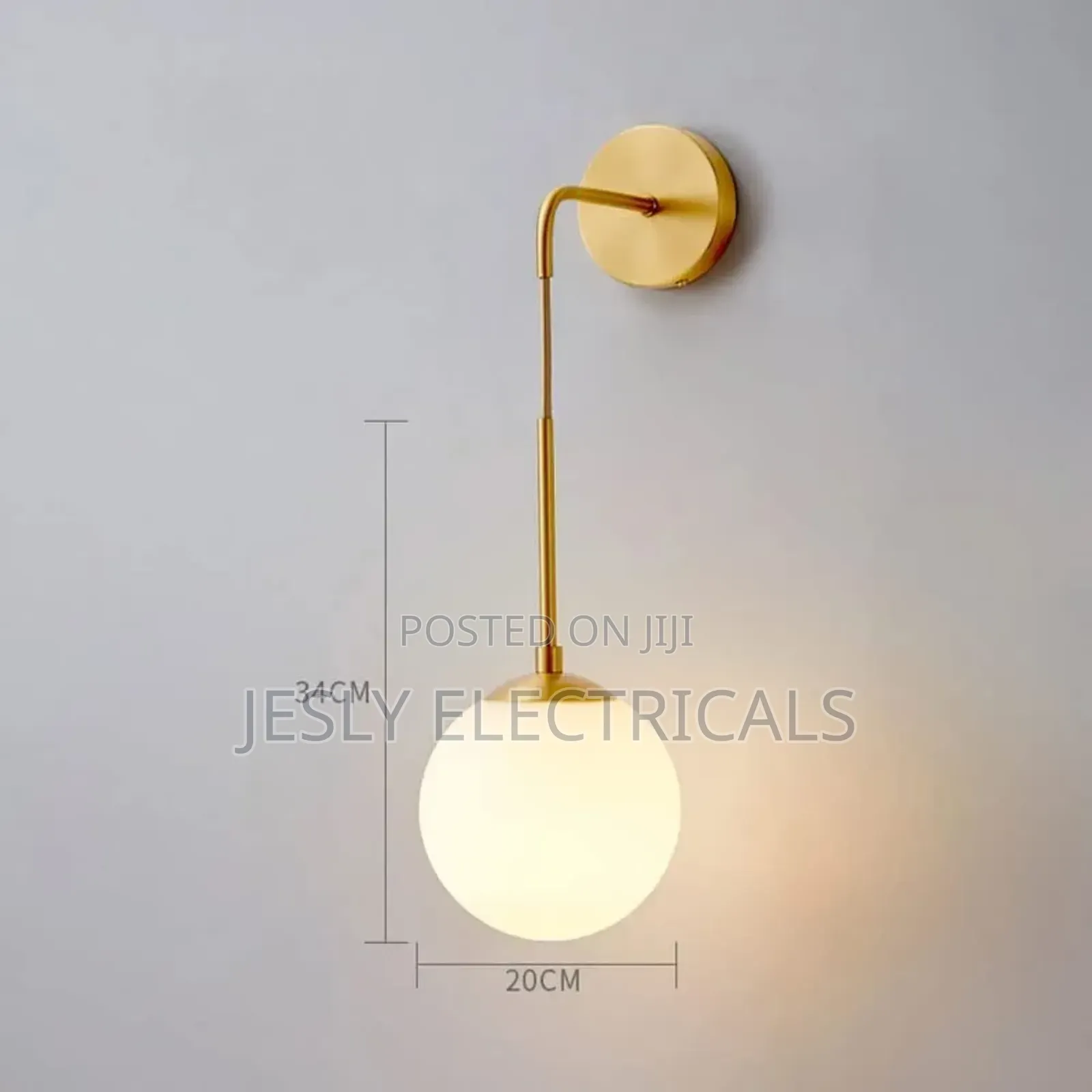 Modern Brass Wall Light With a White Glass Globe Shade.