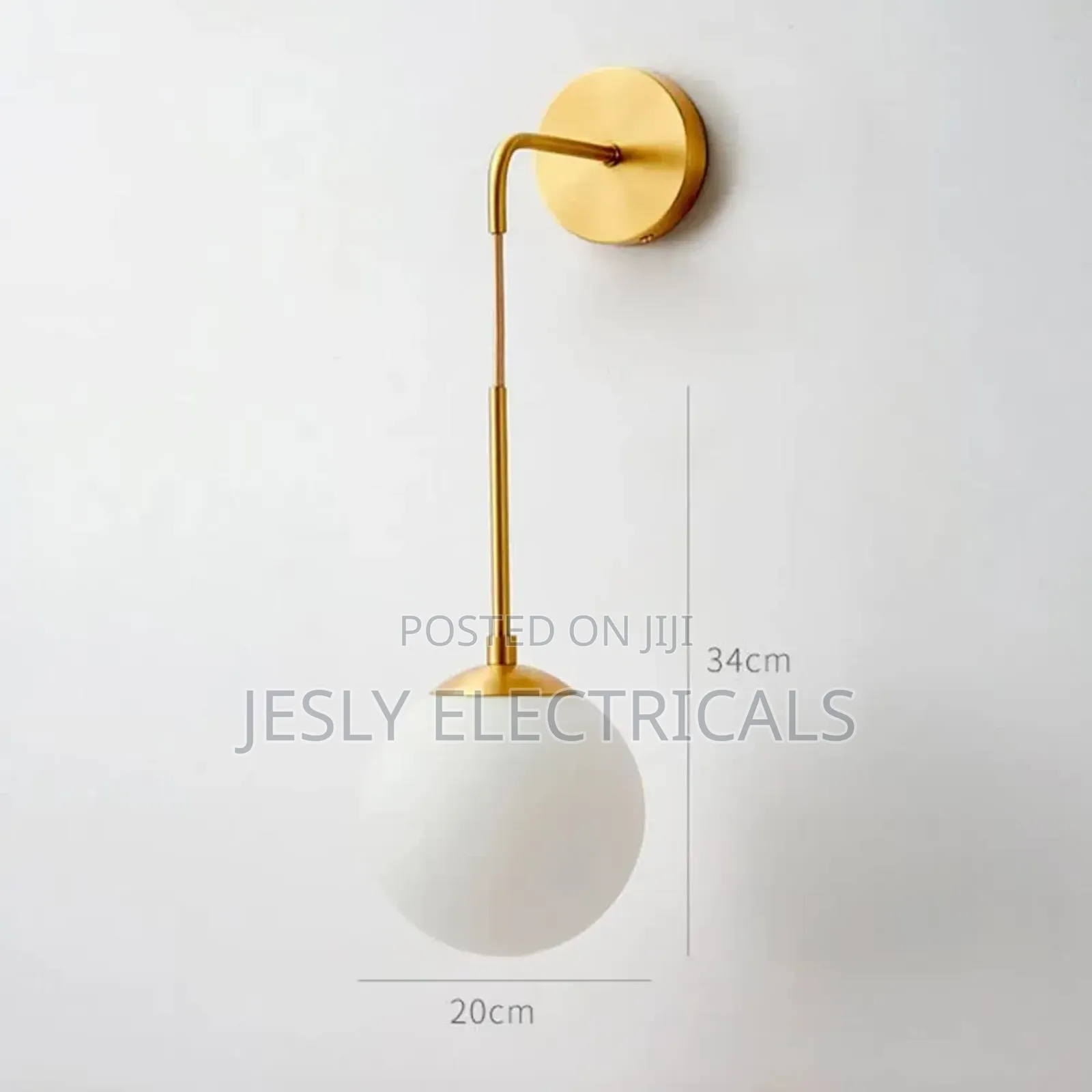 Modern Brass Wall Light With a White Glass Globe Shade.