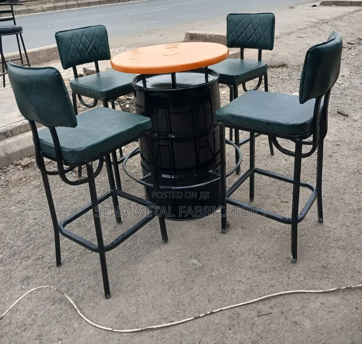 A Metal Drum Set With Green Bar Stools.